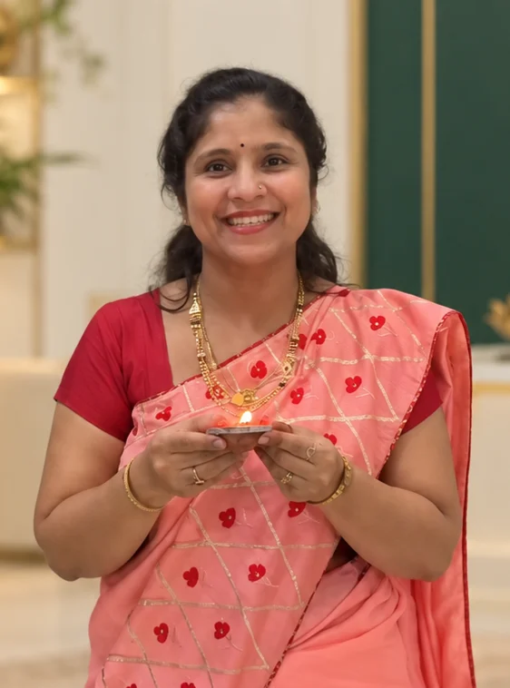 Namrata Harish Mandhane smiling, with an edited ivory, green and gold background